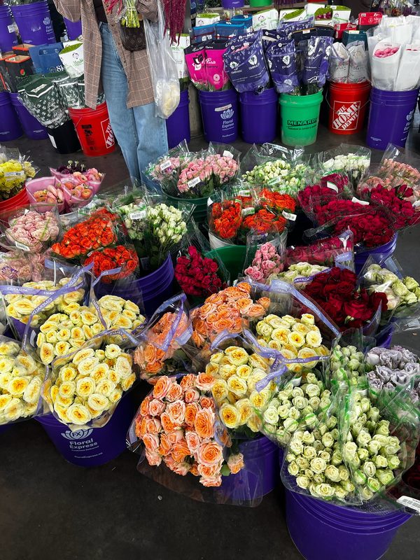 Buckets of fresh roses and ranunculus at the flower market