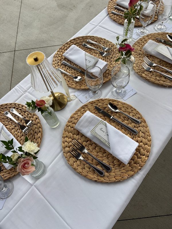 Table setting with a small rose arrangement and gold lamp