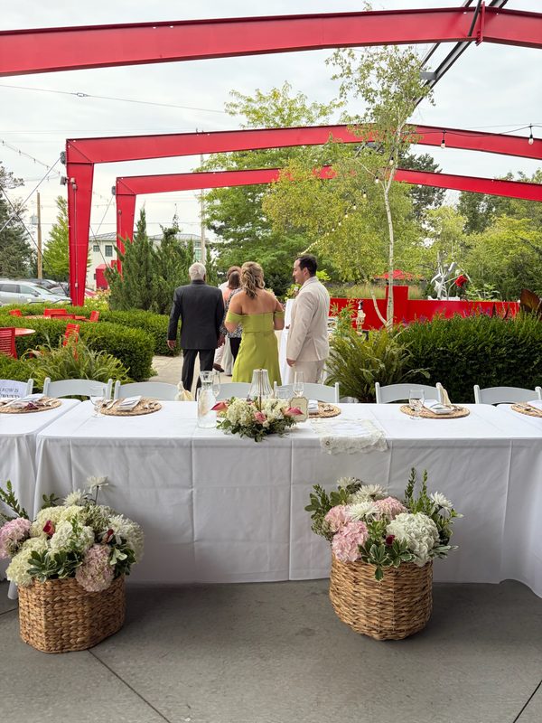 Outdoor reception table flanked by basket arrangements